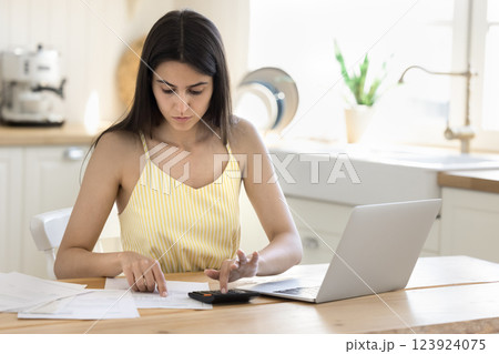 Young woman manage domestic finances calculate expenses at home office 123924075