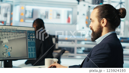 Engineer in photovoltaics factory using PC screen to diagnose malfunctioning systems. Solar panels manufacturing plant worker at computer desk maintaining system operational reliability, camera B 123924193