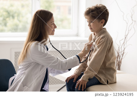 Professional female doctor checking up child patient heart using stethoscope 123924195