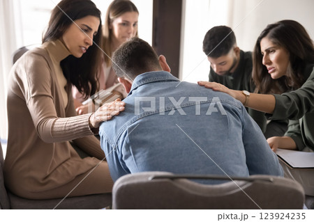 Group of teammates comforting male colleague after failure or dismissal Group of teammates comforting male colleague after failure or dismissal 123924235