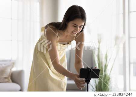 Creative teen girl set smartphone on holder to shoot vlog 123924244