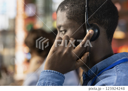 Call center agent dealing with unsatisfied customers, speaking with them using headset in office, close up. African american customer support representative handling clients complaints in workspace Call center agent dealing with unsatisfied customers, speaking with them using headset in office, close up. African american customer support representative handling clients complaints in workspace 123924248