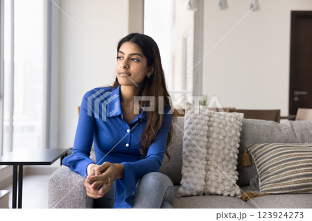 Young Indian woman gaze thoughtfully out of window Young Indian woman gaze thoughtfully out of window 123924273