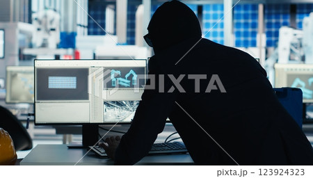 Masked worker in photovoltaics factory commits corporate espionage, stealing proprietary technology using USB stick. Man exploits insider access to copy trade secrets from solar panel plant, camera B 123924323