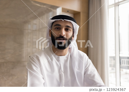 Arabian businessman dressed in traditional muslim dishdasha looking at camera Arabian businessman dressed in traditional muslim dishdasha looking at camera 123924367