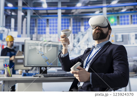 Photovoltaics factory worker using VR technology to analyze and modify assembly line configurations. Solar panels plant expert using virtual reality to do system performance optimizations Photovoltaics factory worker using VR technology to analyze and modify assembly line configurations. Solar panels plant expert using virtual reality to do system performance optimizations 123924370