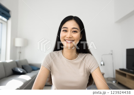 Asian woman sit indoors looking at camera with positive expression 123924438