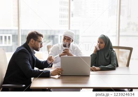 European worker explains insurance coverage details to Arabian couple European worker explains insurance coverage details to Arabian couple 123924634