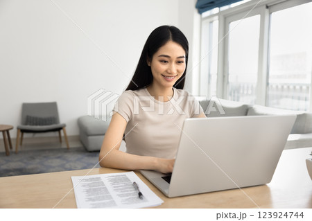 Young woman working on her laptop in fashionable living room 123924744