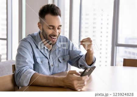 Man holding smartphone reading message with great, fantastic news 123924828