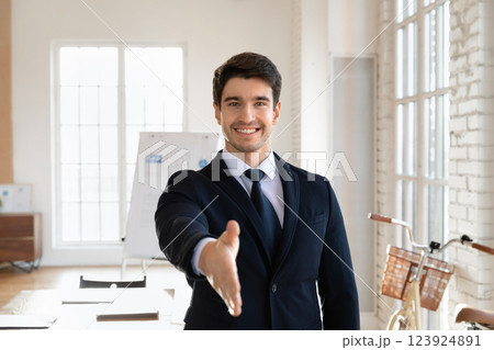 Portrait of professional man in suit extending hand for handshake Portrait of professional man in suit extending hand for handshake 123924891