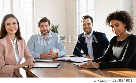 Four businesspeople take part in meeting gathered at conference table Four businesspeople take part in meeting gathered at conference table 123924901