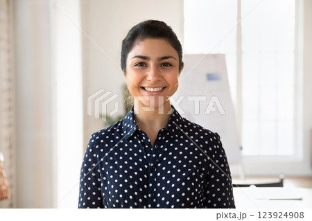Young confident Indian woman wearing casual blouse standing in office 123924908