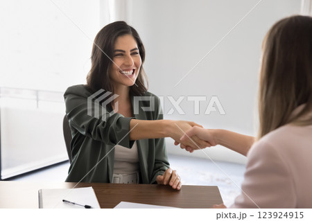 Businesswoman shaking hands partner start or finalize meeting in office Businesswoman shaking hands partner start or finalize meeting in office 123924915