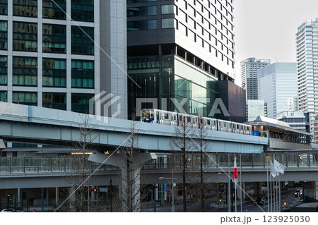 東京のオフィスビルの中をゆく新交通ゆりかもめ 123925030