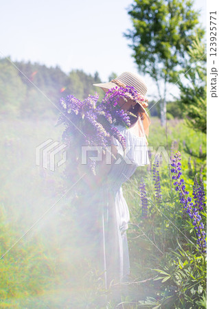 portrait of a girl in a blooming field in the sun at sunset 123925771