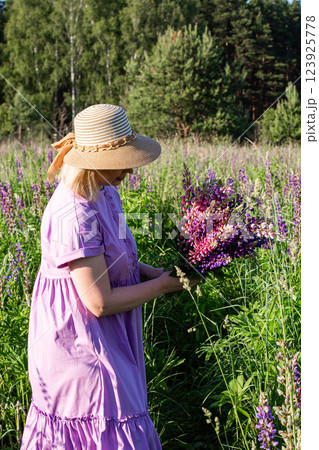 portrait of a girl in a blooming field in the sun at sunset 123925778