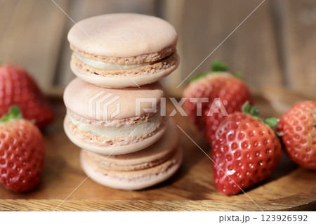 木のお皿にのせたストロベリーマカロンとヘタ付のイチゴ 木のお皿にのせたストロベリーマカロンとヘタ付のイチゴ 123926592