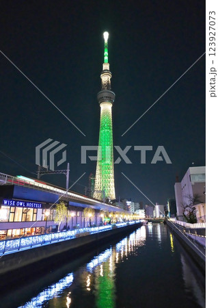 水路沿いのスカイツリーライン電車通過を見守るグリーンのスカイツリー夜景 水路沿いのスカイツリーライン電車通過を見守るグリーンのスカイツリー夜景 123927073
