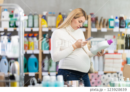 Pregnant shopper scanning fabric softener barcode for mobile payment Pregnant shopper scanning fabric softener barcode for mobile payment 123928639