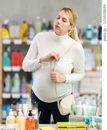 Interested pregnant woman choosing home care products in store 123928684