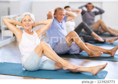 Elderly woman doing pilates in group 123928773