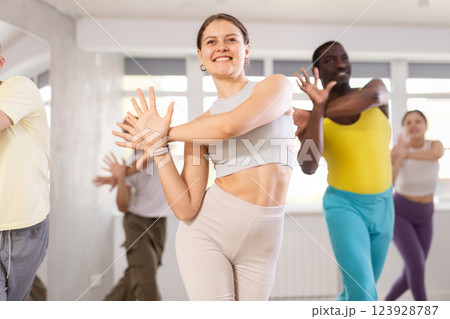 Active multinational men and women of different ages practicing Hip-hop dance in training hall during dancing classes 123928787