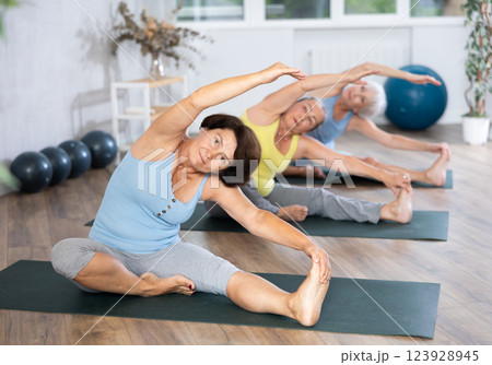 Mature lady performs pose Parivritta janu shirshasana Mature lady performs pose Parivritta janu shirshasana 123928945