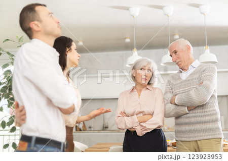 Adult daughter introducing boyfriend to disapproving elderly parents at home 123928953