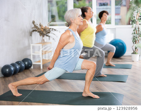 Group of elderly woman doing pilates on mat in studio Group of elderly woman doing pilates on mat in studio 123928956