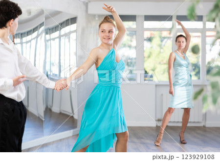 Pair dances - girl and boy in festive attire dance waltz in studio 123929108