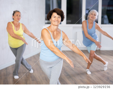 Three elderly women are learning sports Latin American dances in studio class 123929156