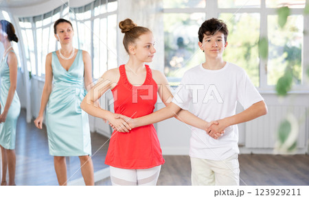 Dance teacher teaching young teenage couple ancient dances Dance teacher teaching young teenage couple ancient dances 123929211