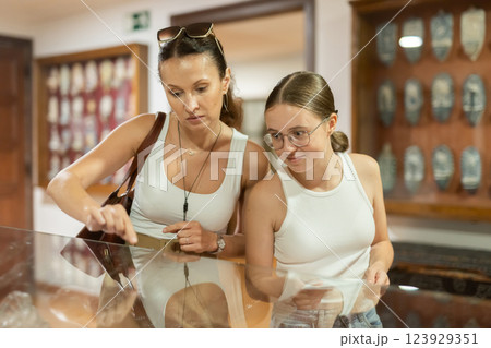 Woman and teenage girl looking at exhibit in museum display 123929351