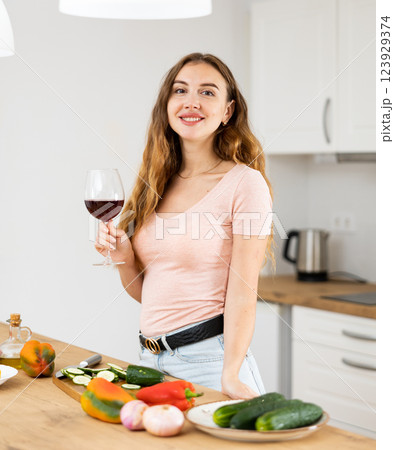 Portrait young woman with a glass of wine in the kitchen Portrait young woman with a glass of wine in the kitchen 123929374