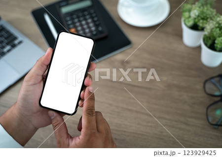 Top view Mockup image hand using a smartphone man Holding Cell Phone With Blank Screen 123929425