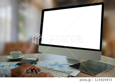 A businessman is using a modern laptop on a white desk in a bright office, typing on a keyboard while viewing a blank screen, showcasing technology and communication. A businessman is using a modern laptop on a white desk in a bright office, typing on a keyboard while viewing a blank screen, showcasing technology and communication. 123929453