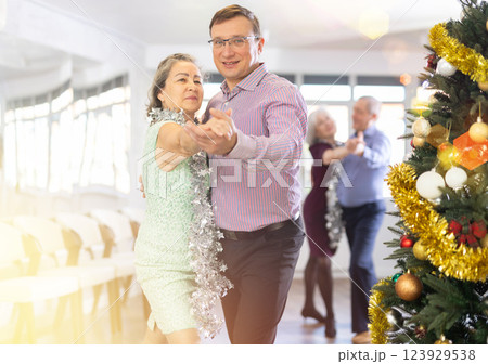 Happy caucasian man and old lady practising paired latin dance in dance studio during celebration Christmas and New Year 123929538
