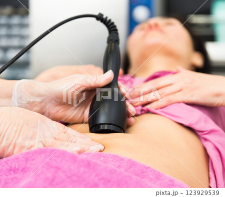 Female abdomen during professional ultrasonic fat cavitation procedure 123929539
