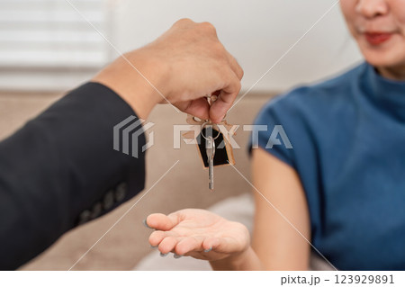 Real estate transaction. Handing over keys to a new homeowner in a warm indoor setting. 123929891