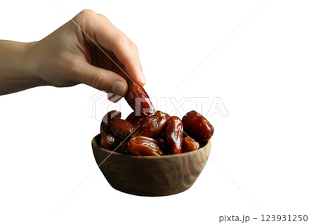 PNG, Ramadan. Hand put date to bowl of dried dates, isolated on white background. 123931250
