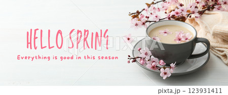Hello spring, cup of coffee and blooming sakura on a light background with text 123931411