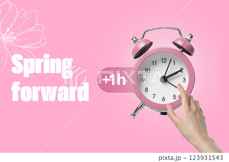 Spring Forward. Alarm clock on a pink background, with the text: "Spring Forward". 123931543