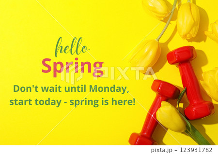 Hello spring, dumbbells and yellow tulips on a yellow background, top view, with text Hello spring, dumbbells and yellow tulips on a yellow background, top view, with text 123931782