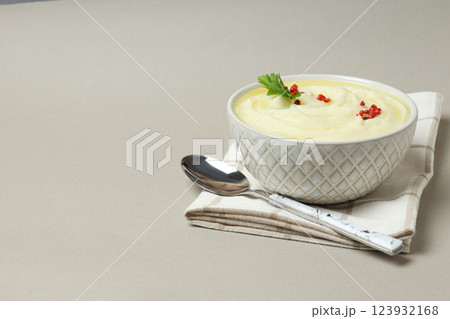 Mashed potatoes in bowl on towel and spoon on gray background, space for text Mashed potatoes in bowl on towel and spoon on gray background, space for text 123932168