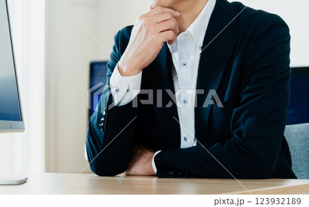 パソコンの前で考えるビジネスマン 123932189