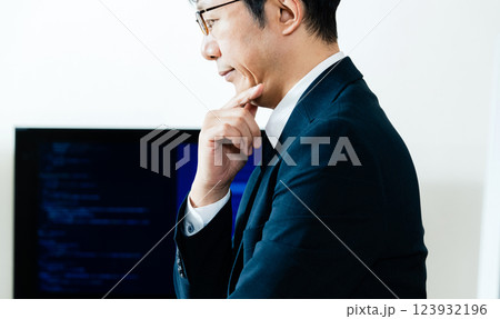 パソコンの前で考えるビジネスマン パソコンの前で考えるビジネスマン 123932196