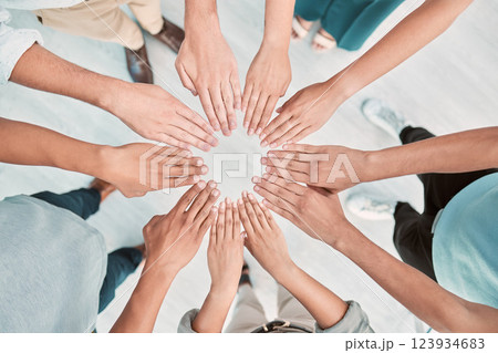 Hands, collaboration and motivation with a business team standing in a huddle or circle from above. Teamwork, goal and unity with a man and woman employee group together in the office for support 123934683