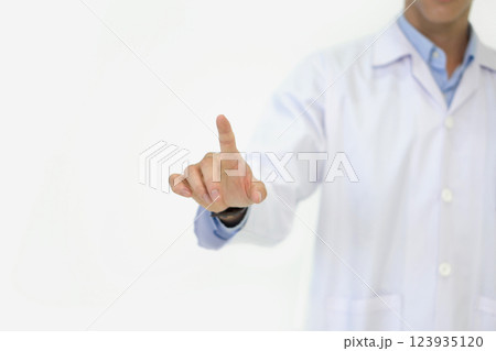 A medical professional in a white coat is pointing with one finger, demonstrating a key concept during a consultation. The background is plain and neutral. A medical professional in a white coat is pointing with one finger, demonstrating a key concept during a consultation. The background is plain and neutral. 123935120
