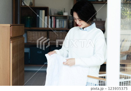 洗濯物ををたたむ女性 123935375